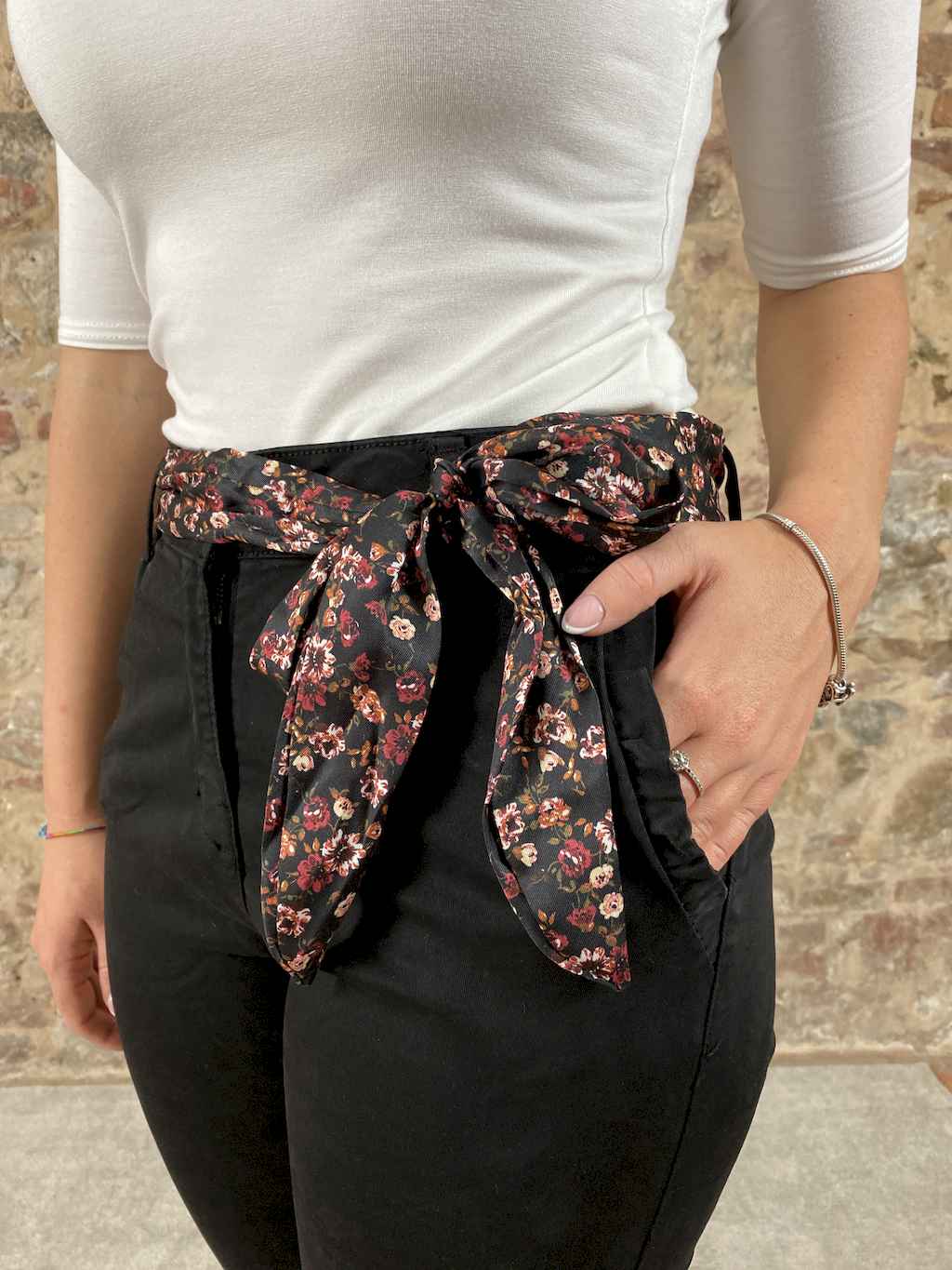 Pantalone elasticizzato con cintura in vita. Chiusura un bottone e zip. Due tasche anteriori con rouches. Due finte tasche posteriori.   Composizione: 95% cotone, 5% elastane.
